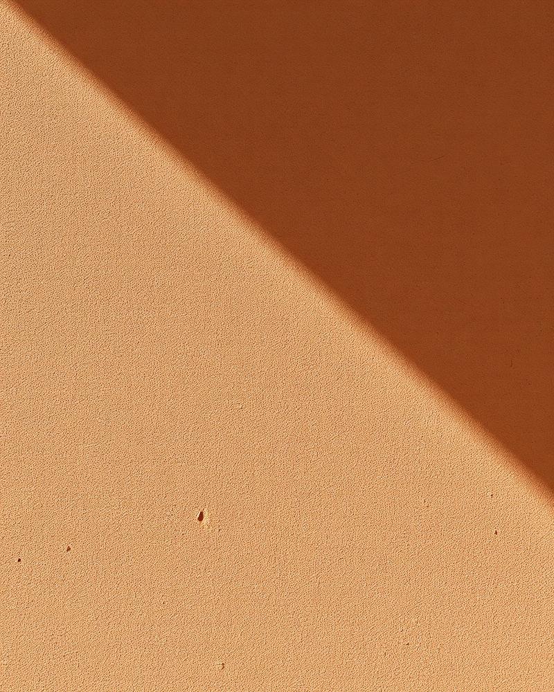 Sunlit clay wall textured in warm afternoon light